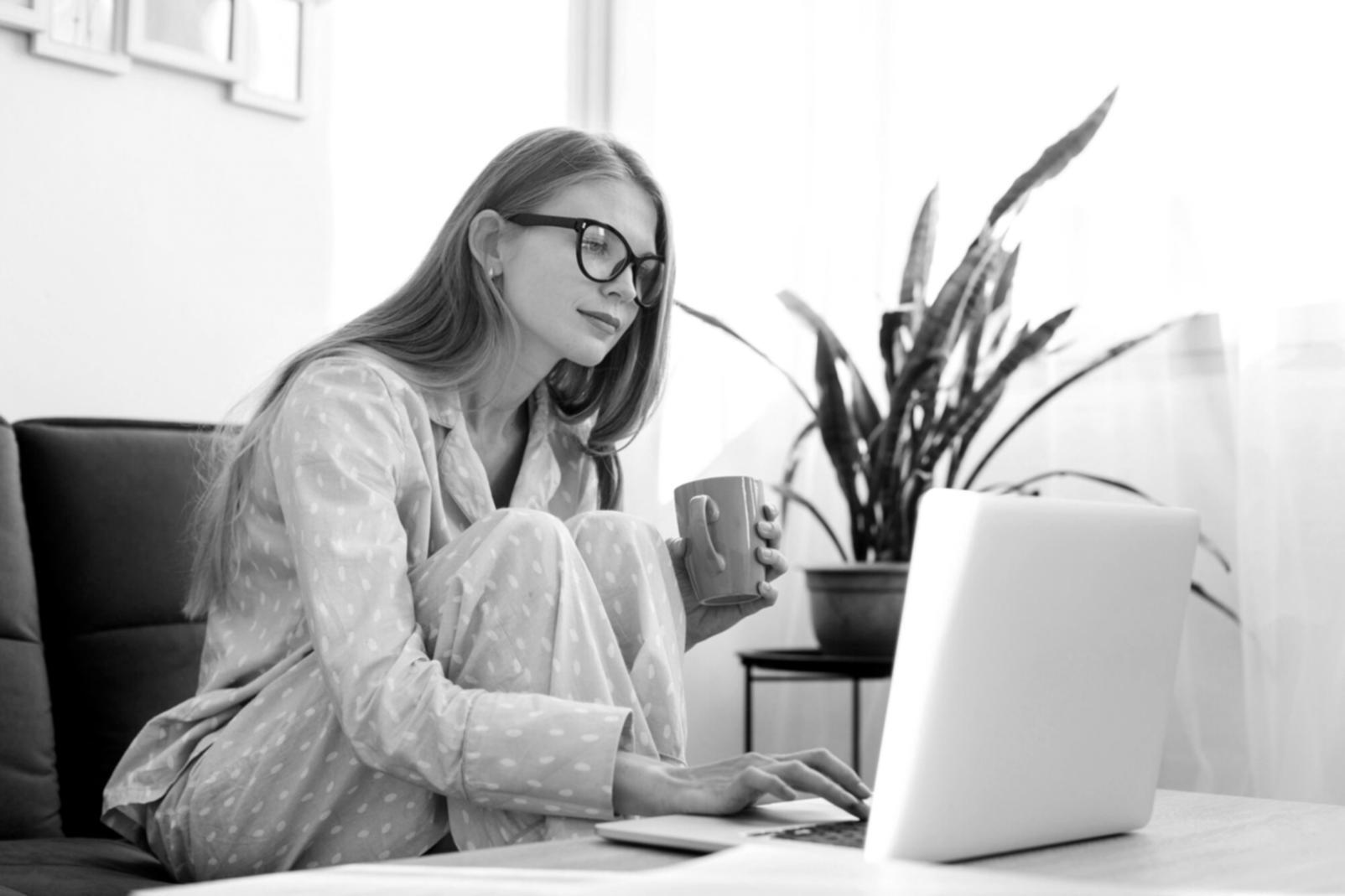 Student working on laptop with multiple learning materials spread across desk